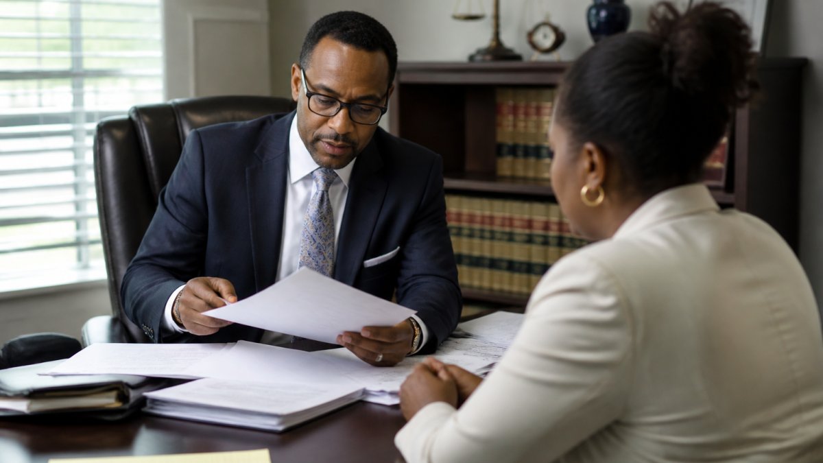 Attorney reviewing medical records with a client to discuss the car accident settlement timeline in a law office.